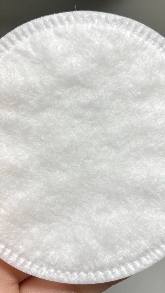 Closeup, small glitter specks on cotton pad.