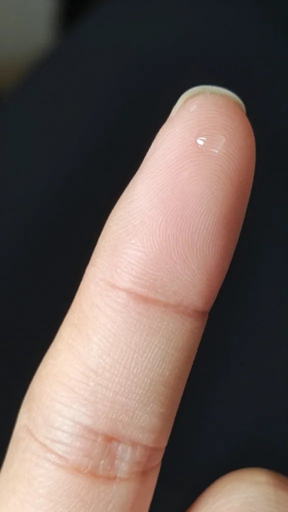 Closeup: single fingernail, cuticle oil droplet